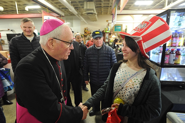 Bishop Richard J. Malone wishes 12-year-old Lancaster resident Catherine Loniewski, who is decked out in a Polish Falcon hat, a Happy Easter during a visit to the Broadway Market on the Saturday morning. (Dan Cappellazzo/Staff Photographer)